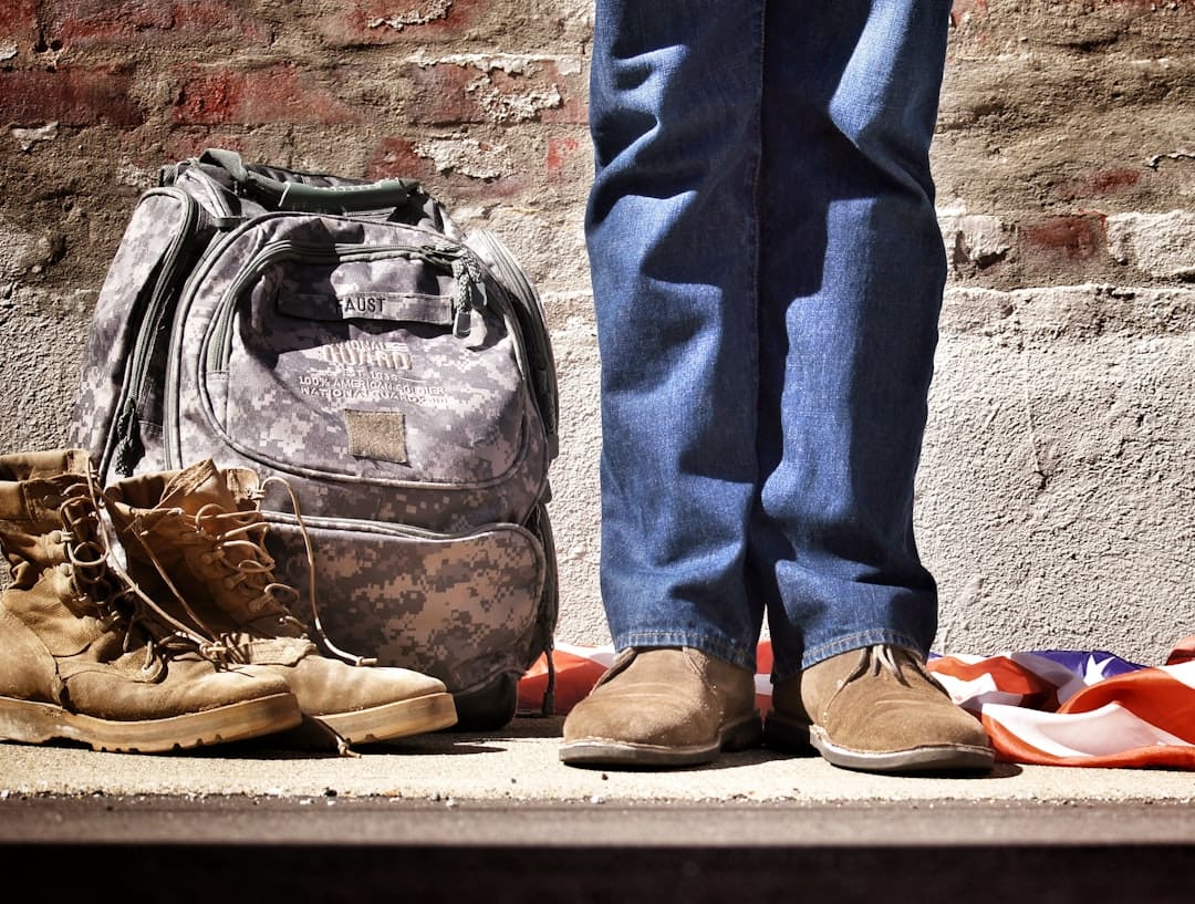 veteran service dogs — minimalist photography of person standing near backpack and boots