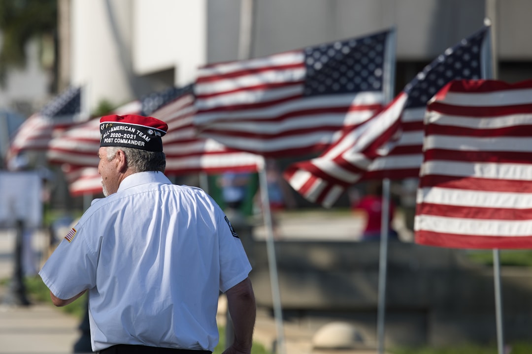 veteran service dog grants — a man standing in front of a row of american flags