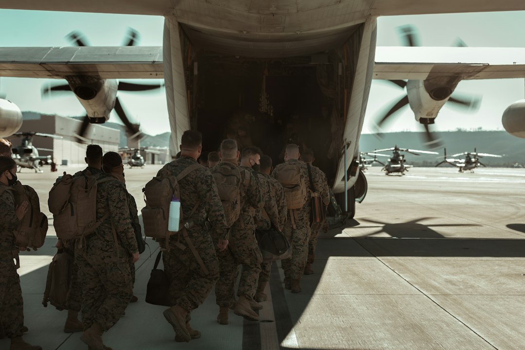 National Guard Reserve service dog — group of men in camouflage uniform standing near white airplane